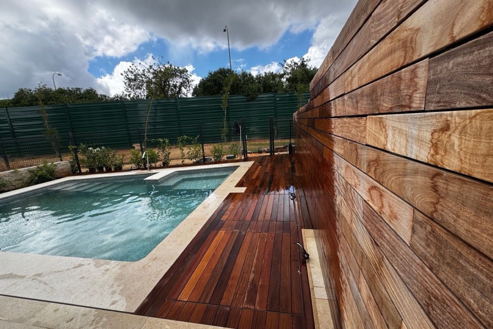 Muro y suelo de madera al lado de una piscina