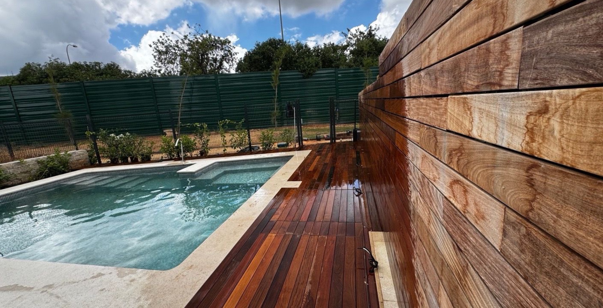 Muro y suelo de madera al lado de una piscina